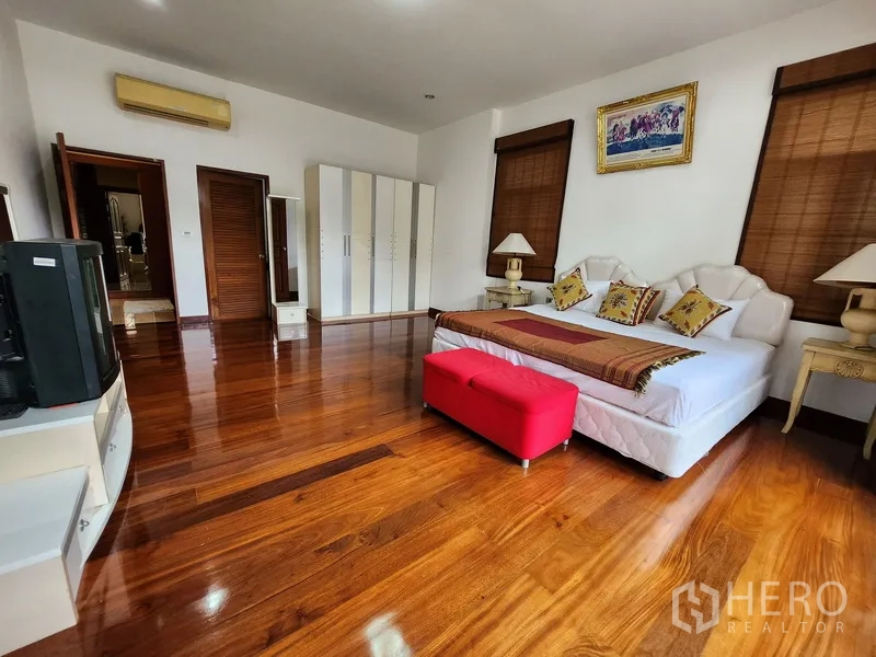 Detached House for rent in Prawet, Bangkok - Airy bedroom with king bed, wardrobes and polished wood floors accented by natural light.