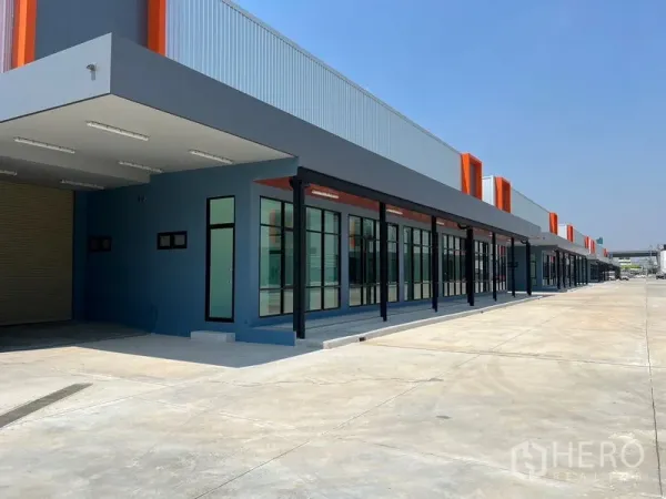 Warehouse for rent in Bang Phli, Samut Prakan - Side perspective of a warehouse bay with canopy lighting, roller shutter and windows