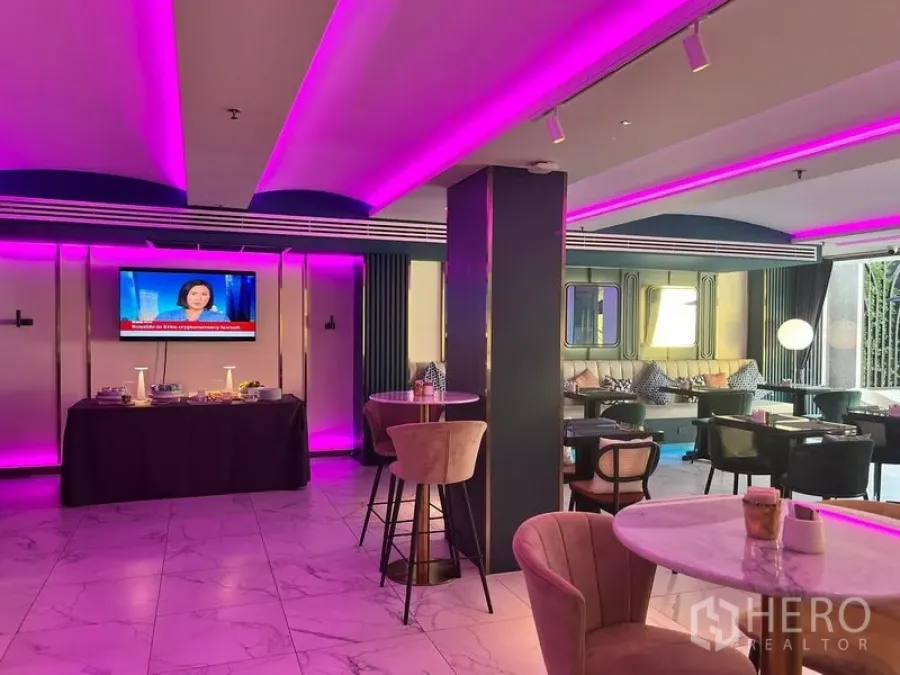 Retail Space for rent - Contemporary retail lounge with pink LED ceiling, marble floors, café tables, bar stools and a TV wall.