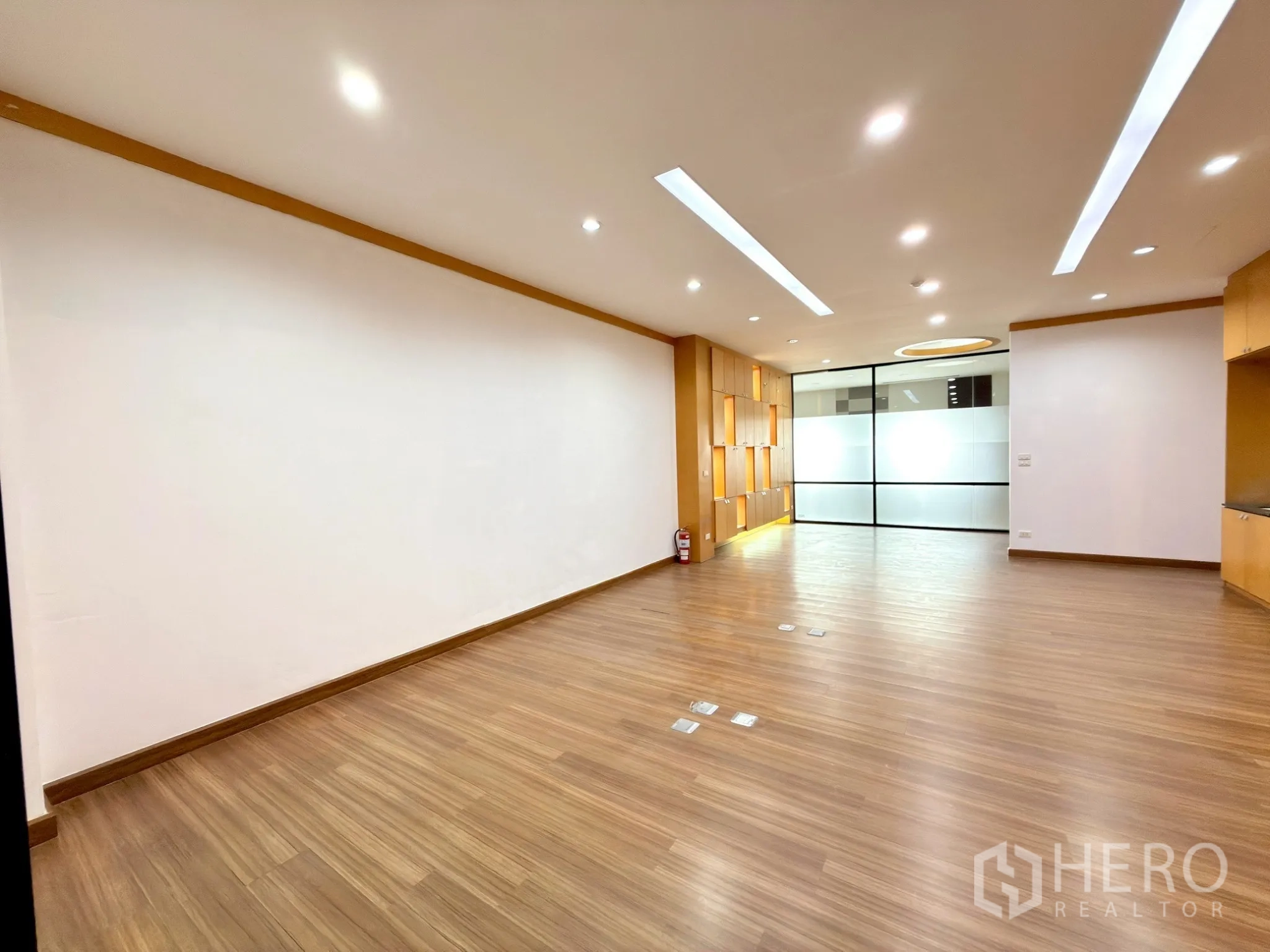 Office Space for rent in Watthana, Bangkok - Large open area with wood floors and feature display niches near the partition wall.