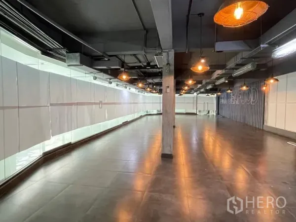 Office Space for rent in Ratchathewi, Bangkok - Wide office area with industrial-style ceiling, structural columns, and continuous glass wall for natural light.