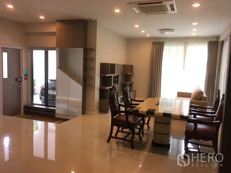 Detached House for rent or sale in Bang Kapi, Bangkok - Ground-floor living area with dining table, staircase and natural light.