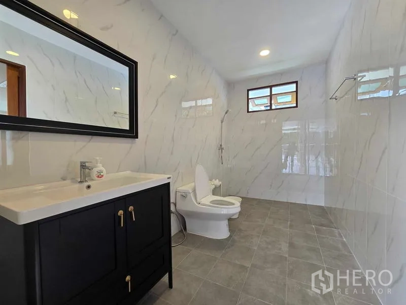 Home Office for rent - Modern bathroom with marble-look wall tiles, black vanity and a walk-in shower.
