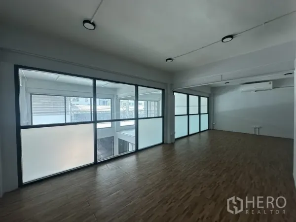 Home Office for rent or sale in Khlong Toei, Bangkok - Bright office floor with wood‑look flooring and large windows with frosted glass partitions.
