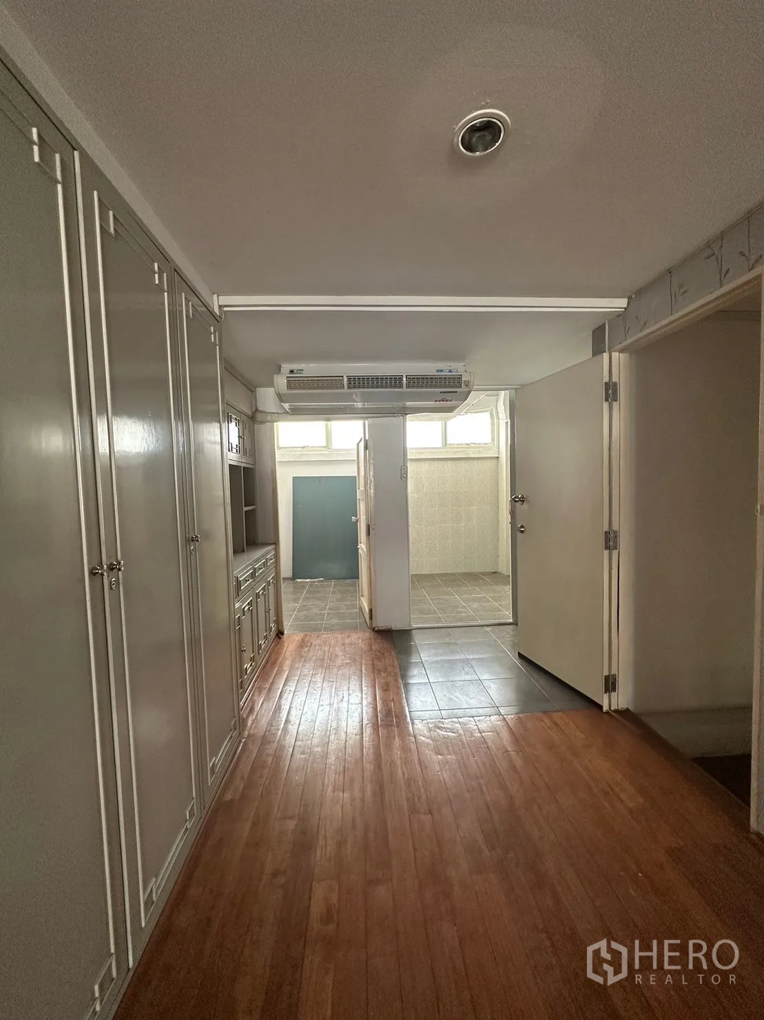Retail Space for rent in Watthana, Bangkok - Hallway with extensive built-in storage opening toward a tiled bathroom