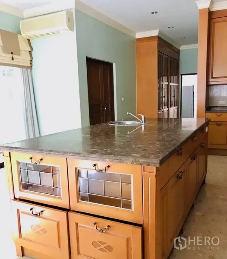 Detached House for rent or sale in Bang Na, Bangkok - Spacious kitchen with marble island, wooden cabinetry and built-in sink in a Bang Na detached house