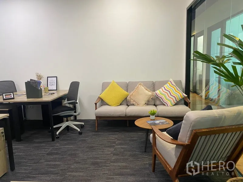 Office Space for rent in Sathon, Bangkok - Cozy lounge with sofas and coffee table beside the work area and a glass partition.