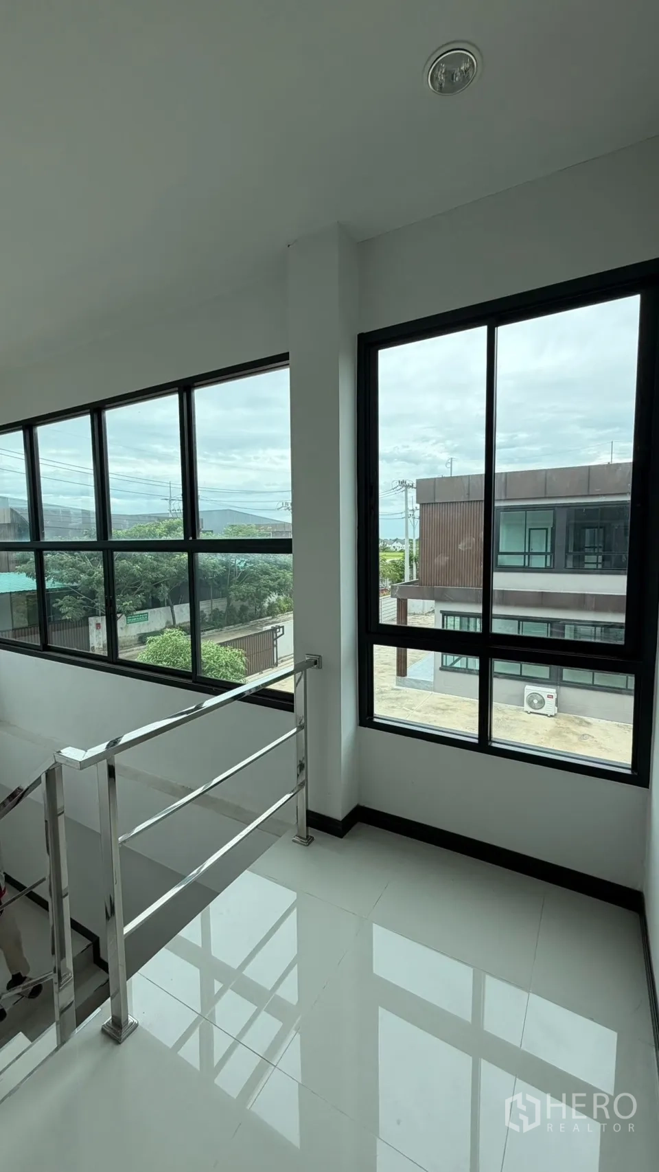 Factory for sale in Bang Len, Nakhon Pathom - Stair landing with floor-to-ceiling corner windows bringing natural light.