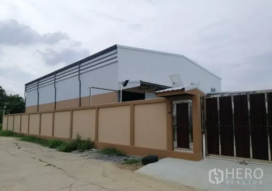 คลังสินค้า ให้เช่าในBang Bua Thong, Nonthaburi - ภายนอกโกดังสมัยใหม่ ผนังเมทัลชีทสูงและกำแพงรั้ว ในย่านบางบัวทอง