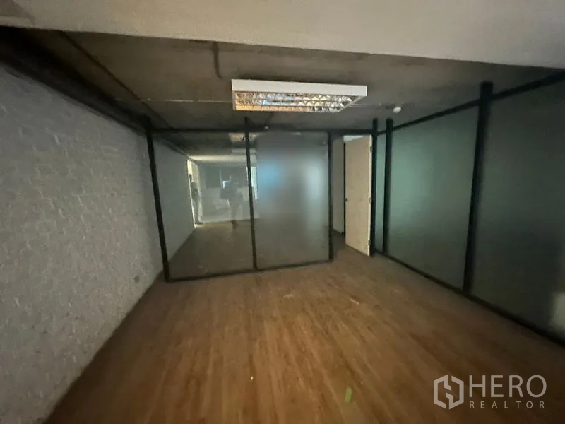 办公空间 出租在Khlong Toei, Bangkok - 封闭办公区，磨砂玻璃隔墙与外露混凝土天花灯具。