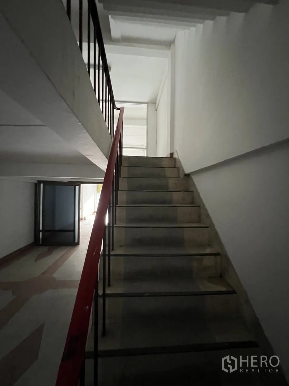 Shophouse for rent in Phra Khanong, Bangkok - Stairway with red handrail leading from ground floor toward upper levels of the shophouse.