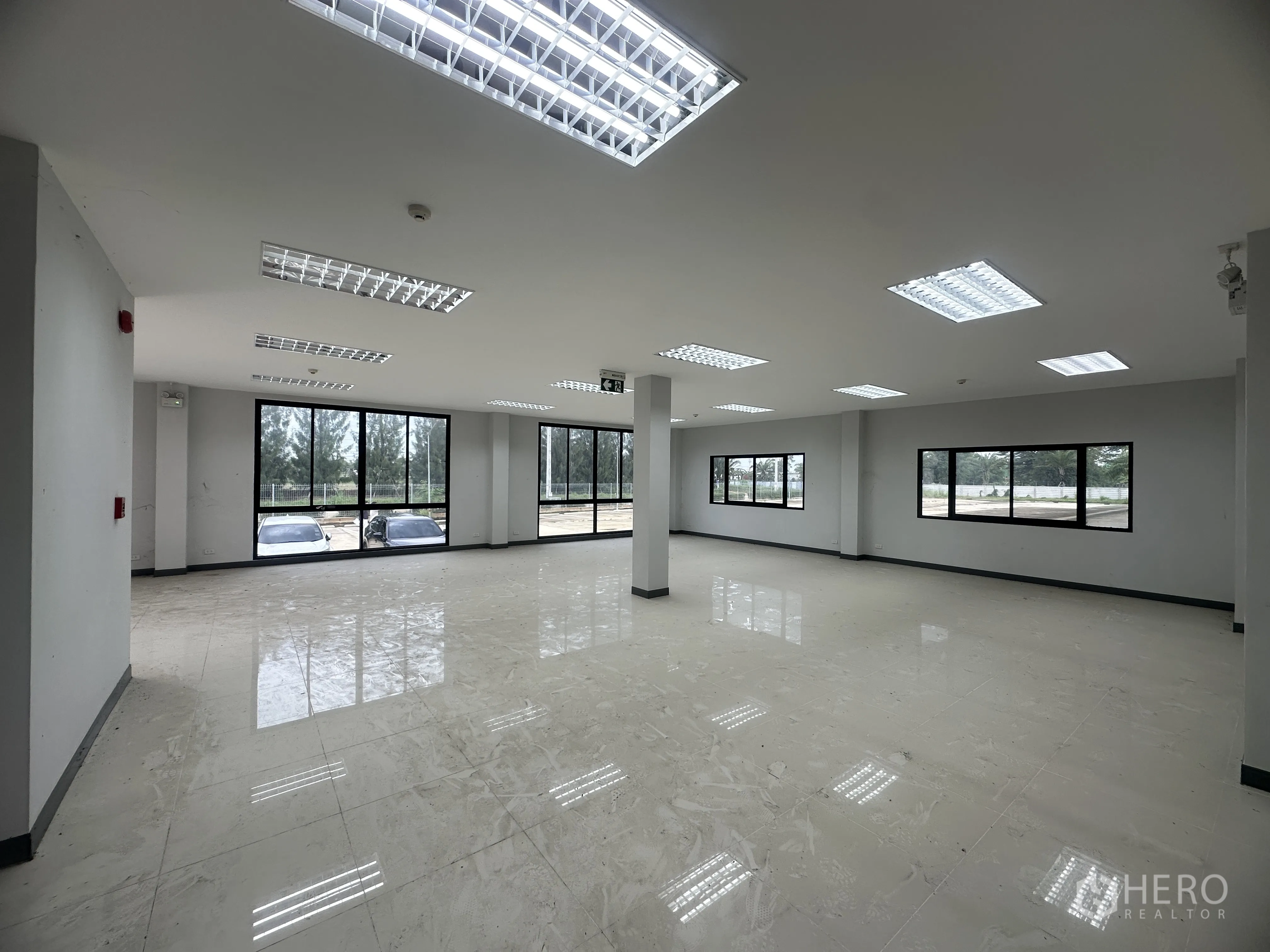 Warehouse for rent in Mueang Chon Buri, Chon Buri - Tiled office area with large windows and grid ceiling lights.