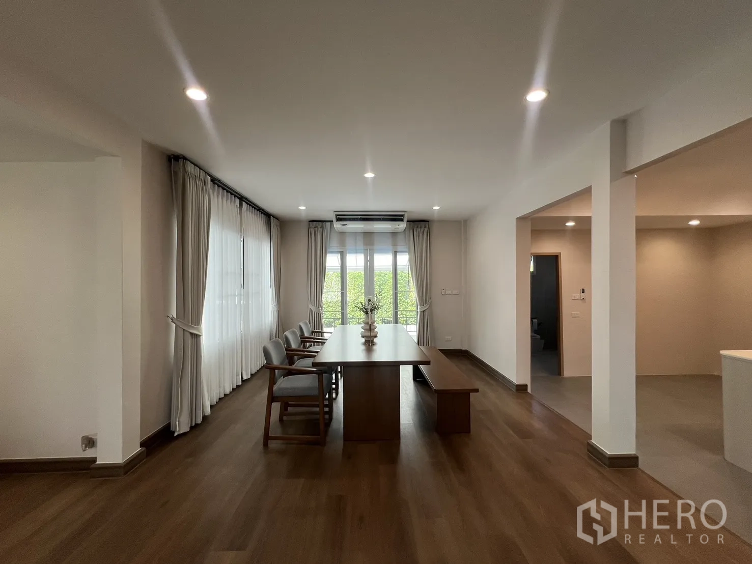 Detached House for rent in Mueang Samut Prakan, Samut Prakan - Close view of dining table facing sliding doors and air conditioner.