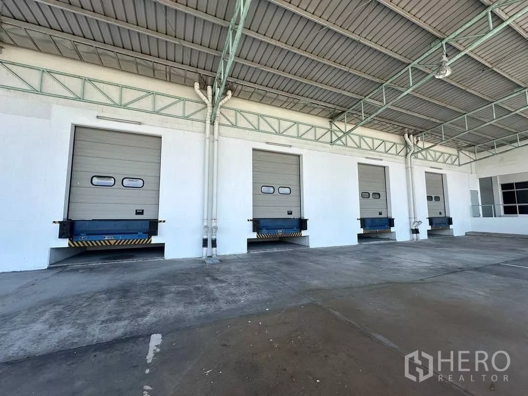 Factory for rent in Si Racha, Chon Buri - Covered loading area with multiple dock-level doors and dock levelers.