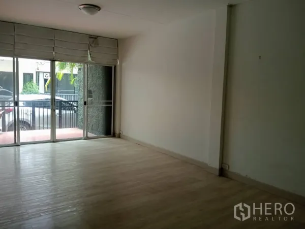 Home Office for rent in Khlong Toei, Bangkok - Ground-floor open-plan room with light wood flooring and full-height sliding doors.