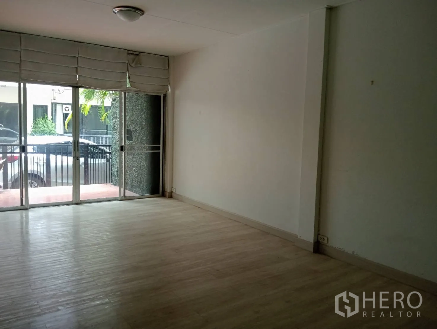 Home Office for rent in Khlong Toei, Bangkok - Ground-floor open-plan room with light wood flooring and full-height sliding doors.