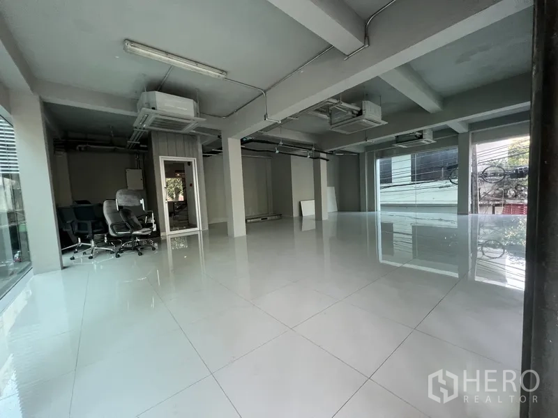 Retail Space for rent in Bang Rak, Bangkok - Spacious retail floor with corner windows, air-conditioning units, and movable office chairs.