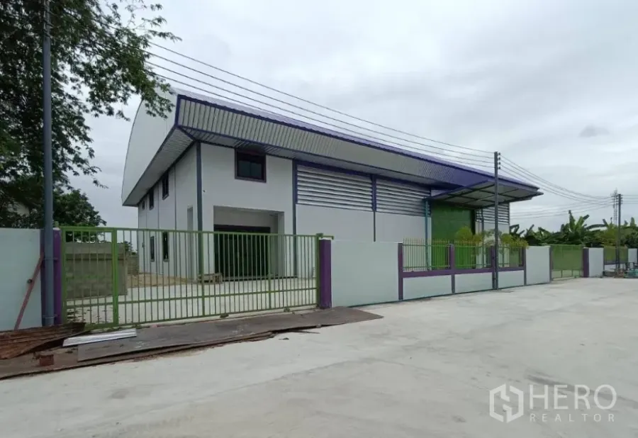 Factory for rent in Lam Luk Ka, Pathum Thani - Modern factory for rent in Lam Luk Ka with green gate, wide driveway and metal roof.