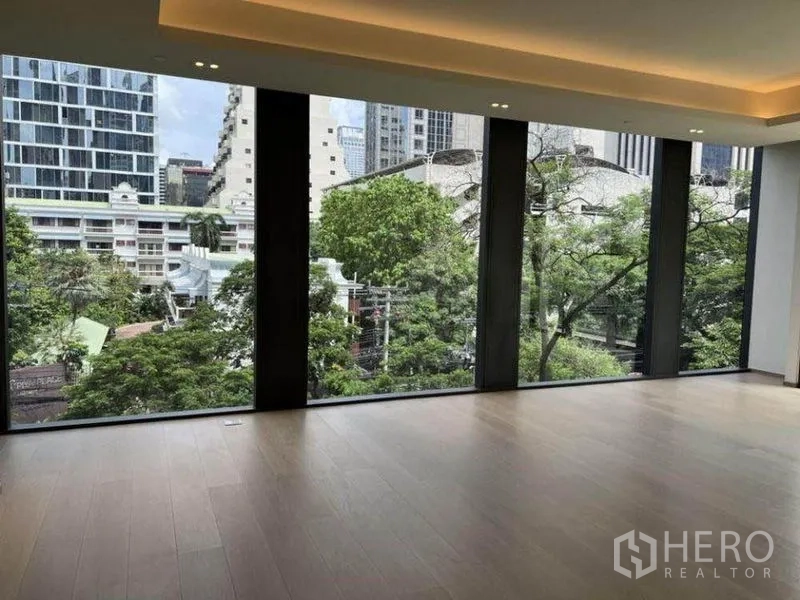Condominium for rent in Pathum Wan, Bangkok - Expansive windows framing treetop and urban views.