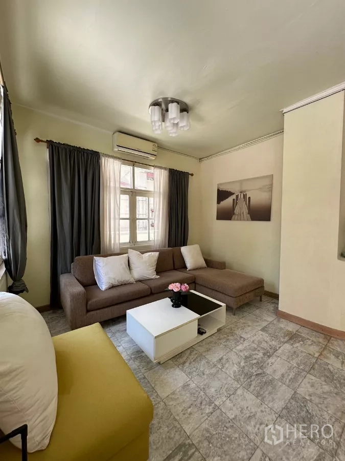 Home Office for rent in Suan Luang, Bangkok - Cozy lounge with sectional sofa, white coffee table, and ceiling light.