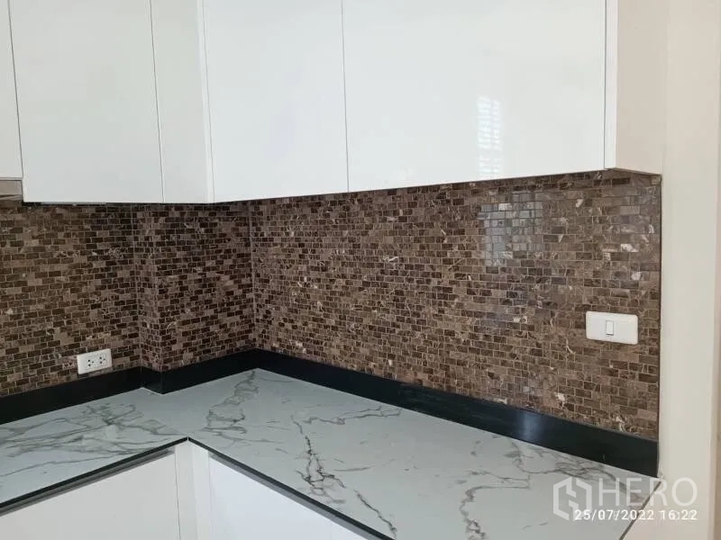 Detached House for sale in Prawet, Bangkok - Close-up of marble-look countertop and mosaic tile backsplash in the kitchen.
