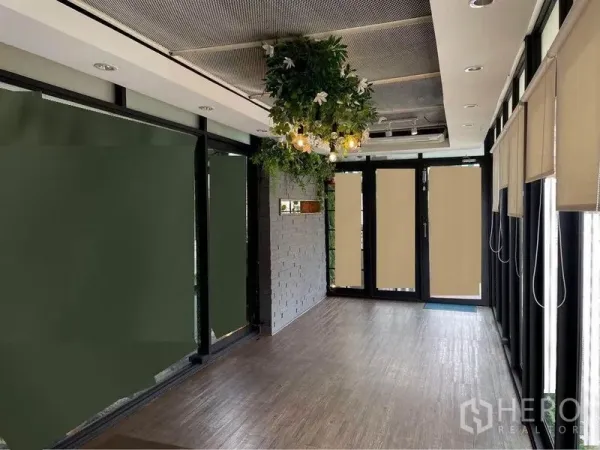 Retail Space for rent in Watthana, Bangkok - Bright retail interior with wood flooring, glass storefront, hanging greenery lights and roller blinds.