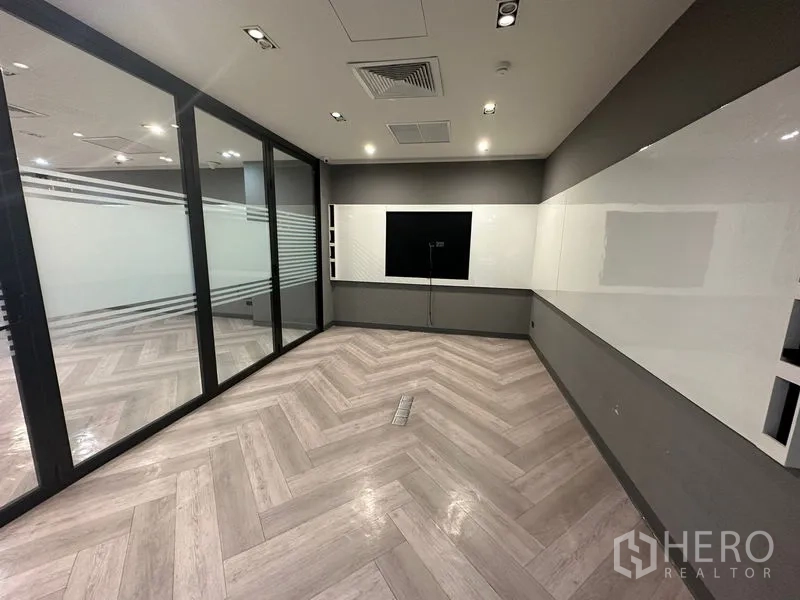 Office Space for rent - Compact meeting room with sliding wood storage, dark feature wall and overhead linear lighting.