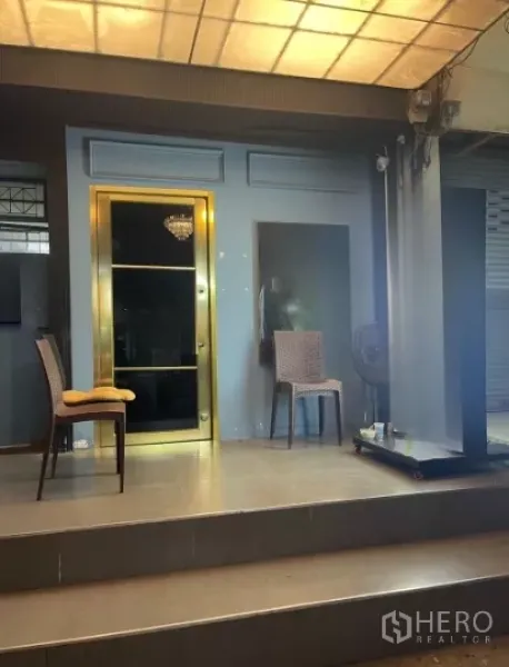 店屋 出租在Watthana, Bangkok - 店屋抬高式入口，玻璃门与座椅，棚下照明明亮。