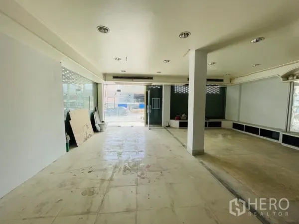 Shophouse for rent in Huai Khwang, Bangkok - Ground-floor retail space with wide glass entrance and tiled floor.