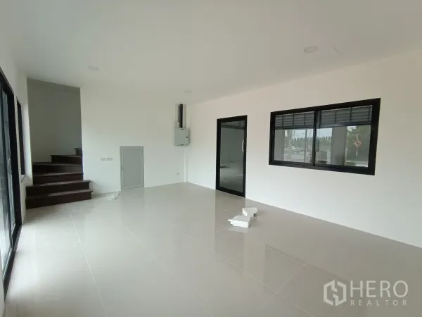 Warehouse for rent or sale in Bang Yai, Nonthaburi - Open‑plan office area with staircase to upper level, sliding windows and glass partition door.
