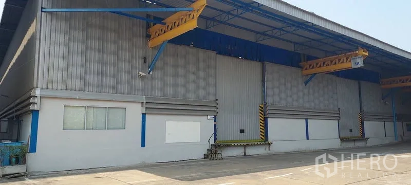 Factory for rent in Phra Pradaeng, Samut Prakan - Exterior of warehouse with raised loading docks and canopy.
