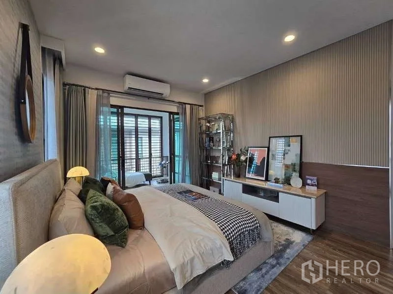 Detached House for rent in Bang Kapi, Bangkok - Master bedroom angle with feature wall, TV console and sliding doors to the balcony.
