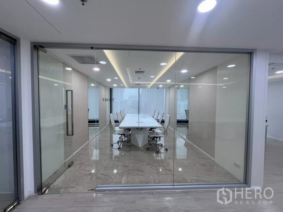 Office Space for rent in Din Daeng, Bangkok - Glass-walled boardroom with a long white conference table, marble floors and ceiling lights overlooking the city.