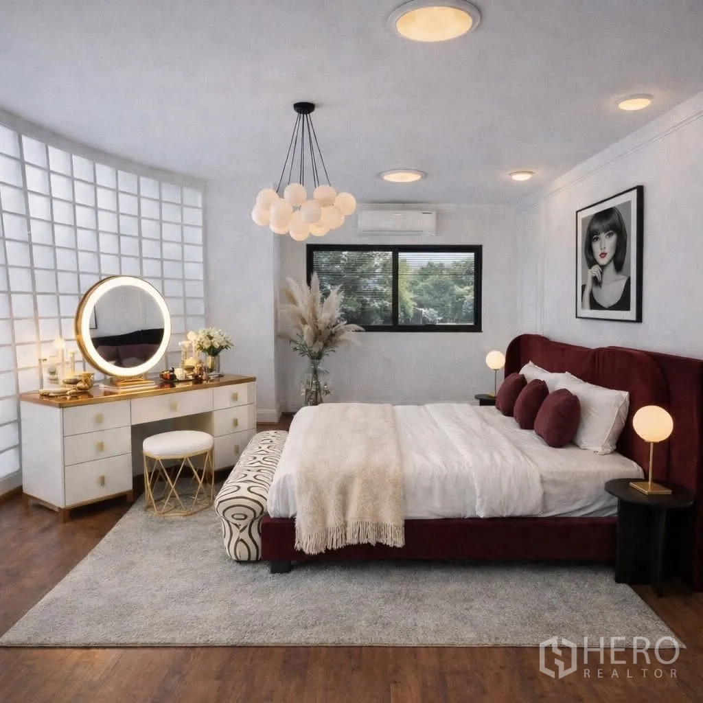 Detached House for rent in Suan Luang, Bangkok - Spacious bedroom with a burgundy upholstered bed, round-mirror vanity and soft lighting.