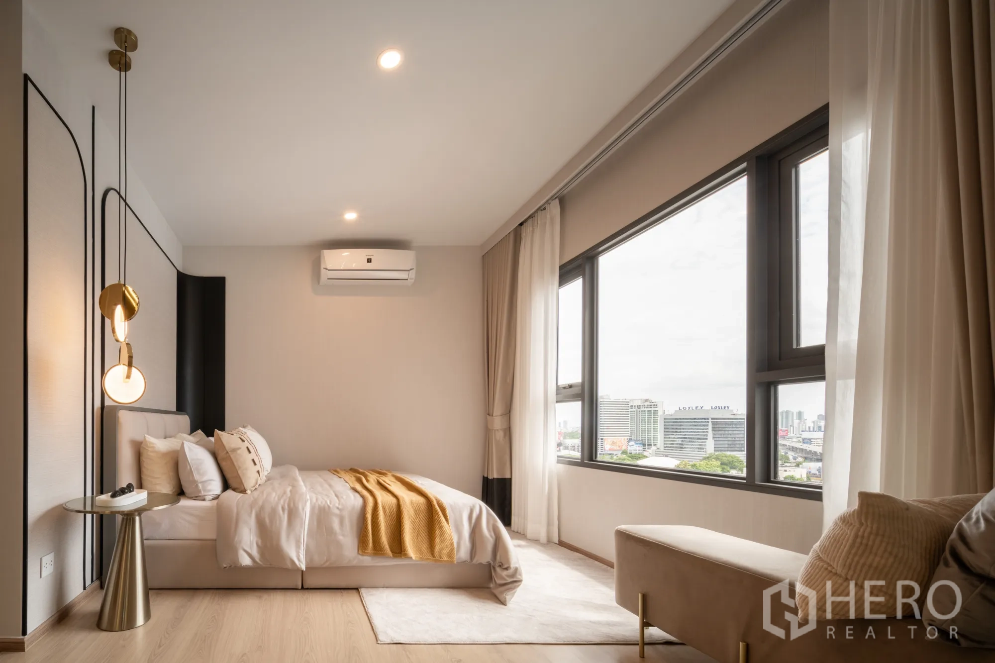 Condominium for sale in Khlong Toei, Bangkok - Spacious bedroom featuring large corner windows, bench seating, and skyline views.