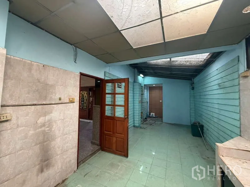带办公室的家 出租在Khlong Toei, Bangkok - 带天窗的半室外后勤区，薄荷绿墙面与木门相连室内。