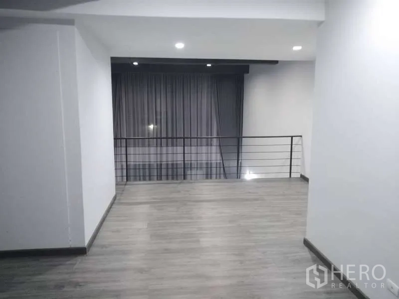 Home Office for rent or sale - Mezzanine workspace with wood flooring, black metal railing, recessed lighting and full-length curtains.