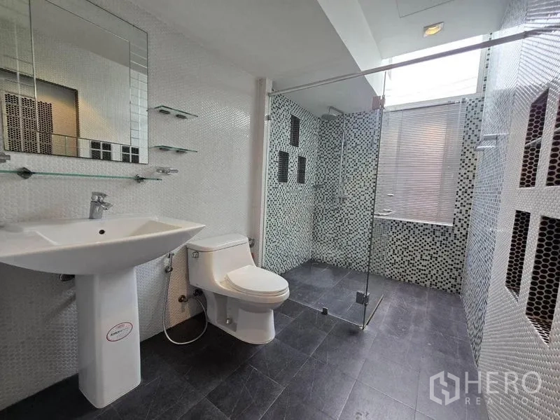 Detached House for rent in Suan Luang, Bangkok - Bright bathroom with glass shower, pedestal sink and window.