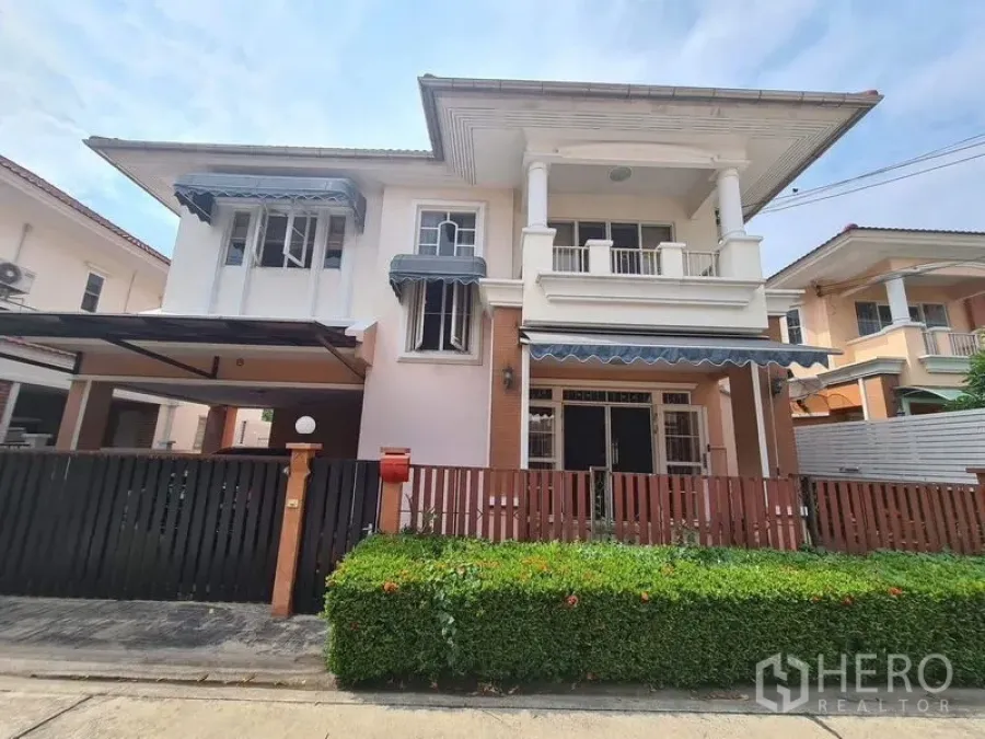 Detached House for rent in Sai Mai, Bangkok - Street view of the detached house facade with front hedge and gated fence.