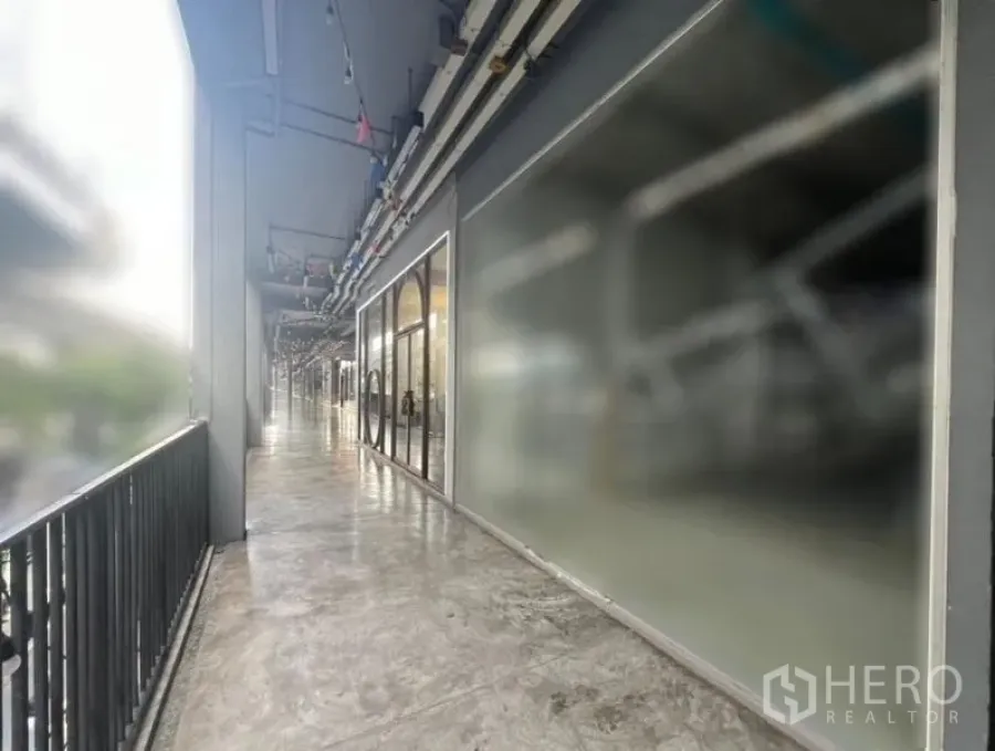 Retail Space for rent in Khlong Toei, Bangkok - Open-air corridor with shopfronts and railing outside the unit.