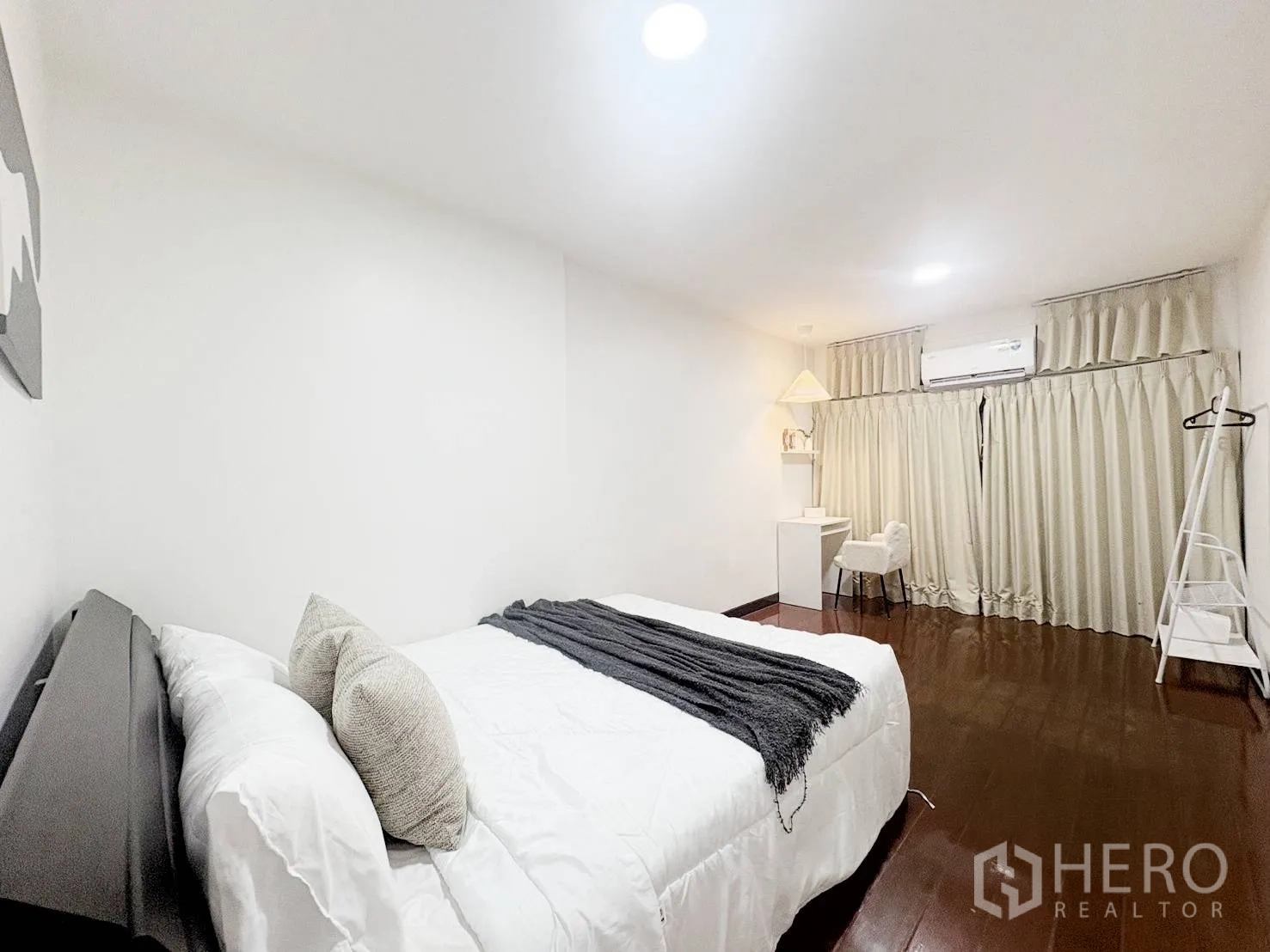 Detached House for rent in Huai Khwang, Bangkok - Large bedroom with bed, work desk, air conditioner, curtains, and ladder-style rack.