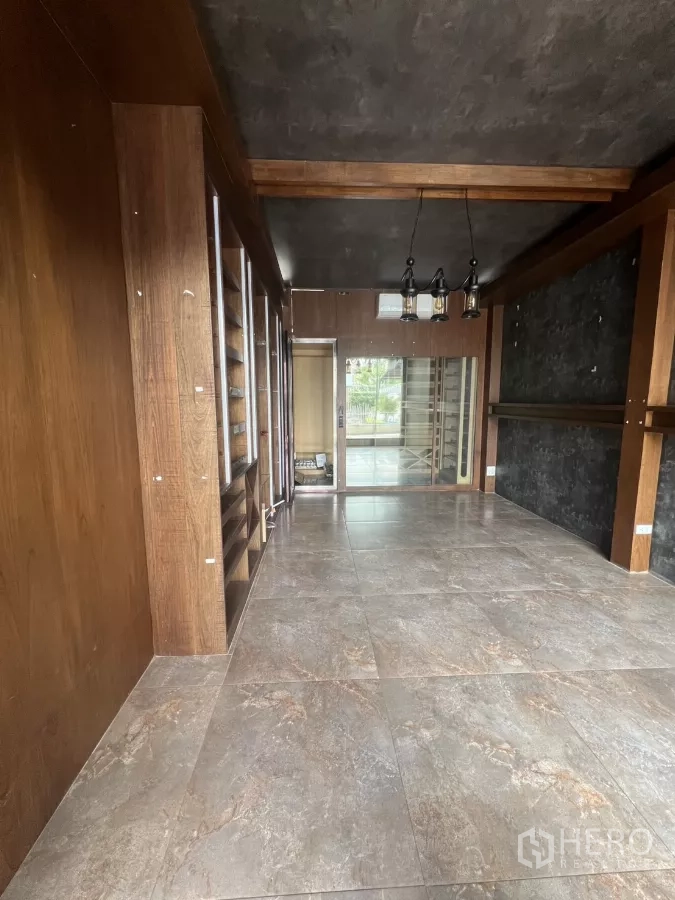 Retail Space for rent - Compact shop room with stone-look tiles, built-in wood shelving and pendant lighting.