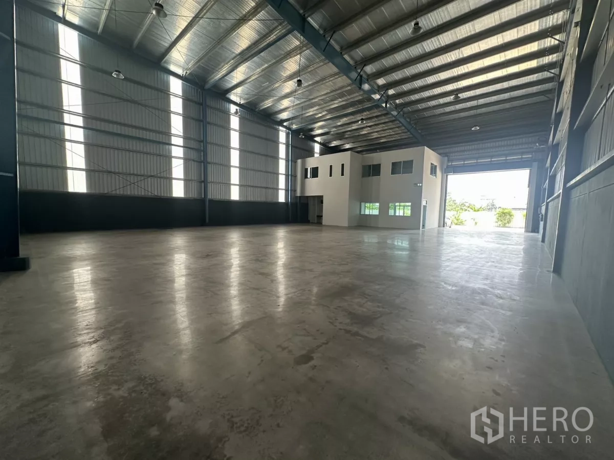 Factory for rent in Bang Phli, Samut Prakan - Expansive warehouse interior showing high roller door and built-in two-story office block.