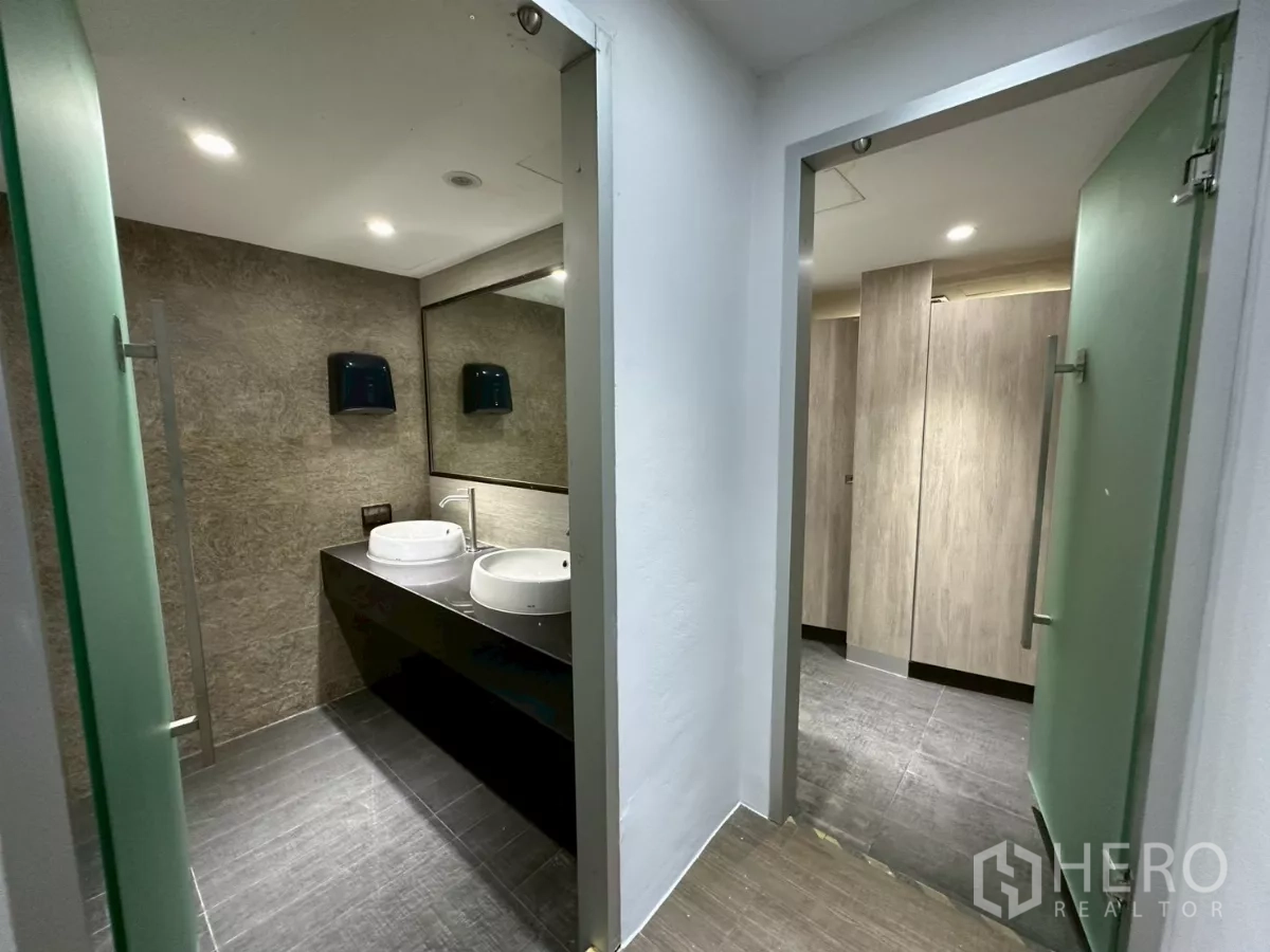 Office Space for rent in Khlong Toei, Bangkok - Modern restroom with double vessel sinks, large mirror and private cubicles.