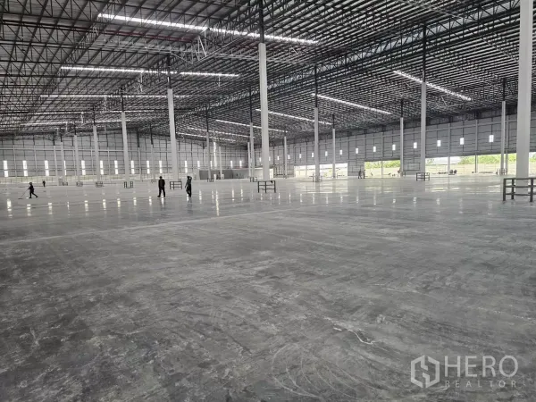 Factory for rent in Chon Buri - Vast warehouse interior with polished concrete floor, high truss roof and lines of steel columns.