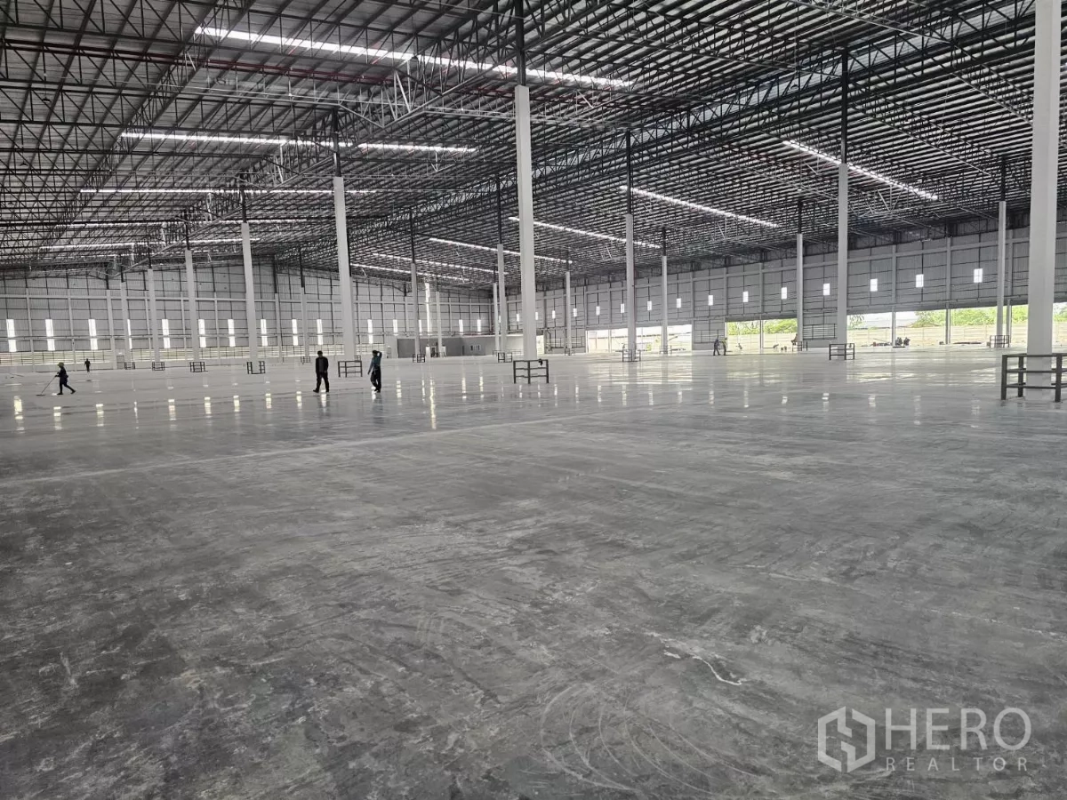 Factory for rent in Chon Buri - Vast warehouse interior with polished concrete floor, high truss roof and lines of steel columns.