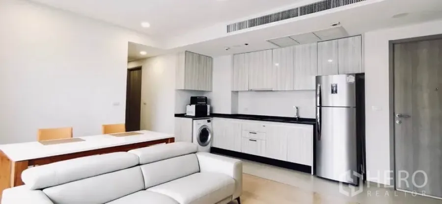 Condominium for rent or sale in Watthana, Bangkok - Full view of open kitchen with stainless refrigerator and white cabinetry.