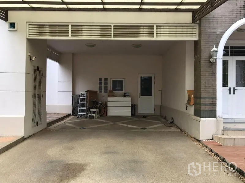 Detached House for rent in Bang Khen, Bangkok - Covered carport with parking for two vehicles and side entry door.