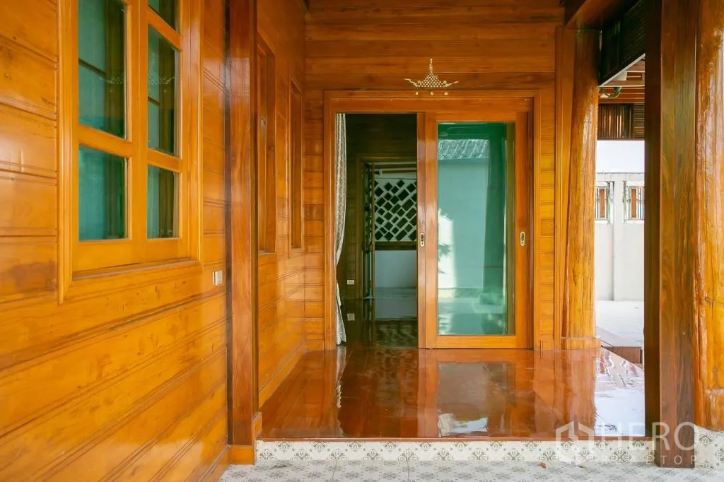 Detached House for rent or sale in Huai Khwang, Bangkok - Covered wooden porch with sliding glass doors and windows.