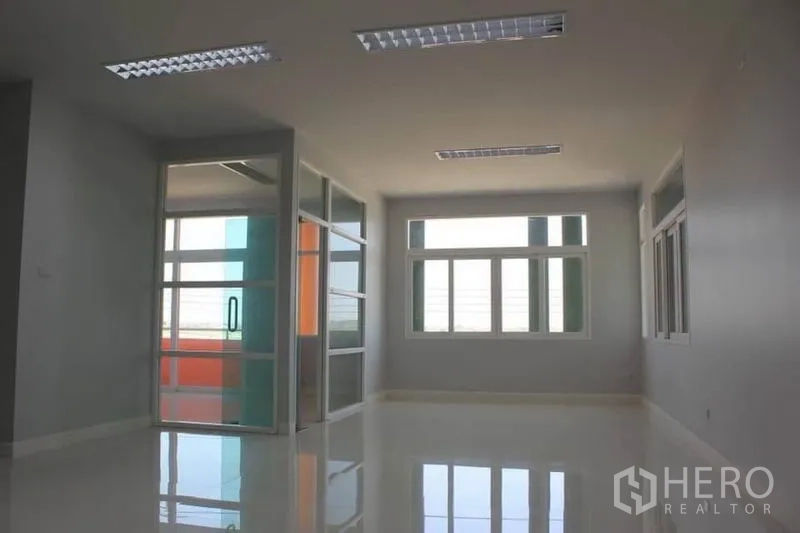 Factory for rent or sale in Lam Luk Ka, Pathum Thani - Second-floor office space with glass partitions and wide windows.